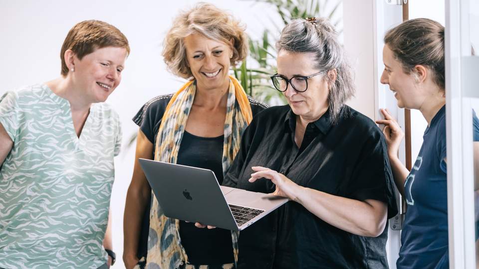 4 collega's staan samen 